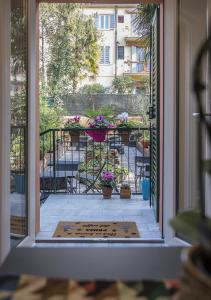 una puerta abierta a un patio con una mesa y flores en Le Stanze dei Fiori, en Bolonia