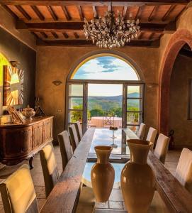 a dining room with a long table and a chandelier at Countryhouse Villa Rey in Panicale