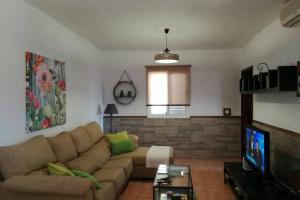 a living room with a couch and a tv at Casa rural con piscina privada Manitaga. in Tuineje