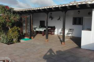 um pátio com uma pérgola e uma mesa em Casa rural con piscina privada Manitaga. em Tuineje