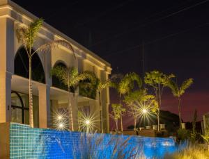 a building with palm trees in front of it at night at Class Hotel Piracicaba in Piracicaba