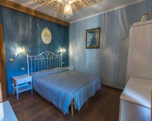 a bedroom with a bed and a blue wall at Le sou tri in Aosta