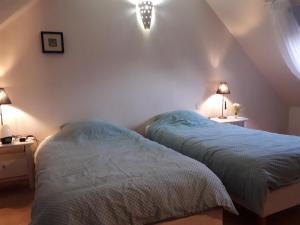 サン・ブリューにあるChambre maison de ville dans la cité des trois valléesのベッドルーム1室(ベッド2台、壁に照明2つ付)