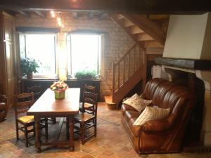 een woonkamer met een tafel en een leren bank bij Auberge Les Tilleuls in Vincelottes