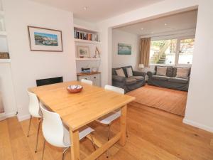 a kitchen and living room with a wooden table and chairs at George Cottage in Dartmouth