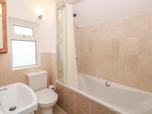 ein Badezimmer mit Toilette, Badewanne und Waschbecken in der Unterkunft George Cottage in Dartmouth