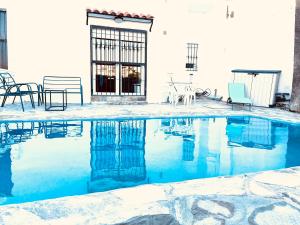 a swimming pool with blue water in front of a house at Exclusive New Apartment in Benalmádena