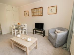 a living room with a couch and a table at Maisie's Cottage in Dunblane