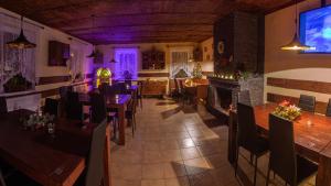 a restaurant with tables and chairs and a fireplace at WELLNESS Penzion Triola in Kořenov