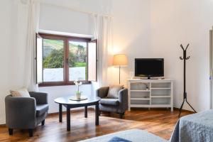a living room with a tv and a table and chairs at Casa Maria Dolores in Haría