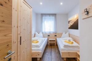 a room with two beds and a window at Baumannhof Villnöss in Funes