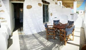 a patio with a table and chairs on a house at John's Houses in Koufonisia