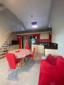 uma cozinha e sala de jantar com mesa e cadeiras vermelhas em Gites Bretzel et Cigogne em Munwiller