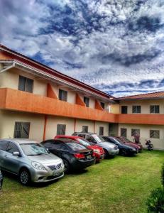 un grupo de coches estacionados frente a un edificio en Apartamentos PraiaMar en Ilha Comprida