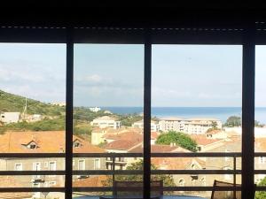 a view of the ocean from a window at Jardins de Quatrina in Propriano