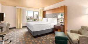 una habitación de hotel con una cama y una silla en Holiday Inn Yakima by IHG, en Yakima