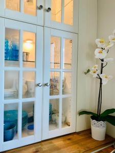 un armario blanco con puertas de cristal con platos. en Blue View House en Corfú