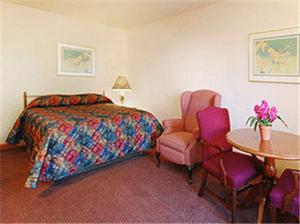 a bedroom with a bed and a table and a chair at Atlantic Motel in East Wareham