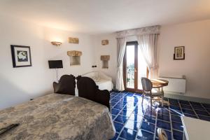 1 dormitorio con 1 cama, mesa y sillas en Masseria Ruri Pulcra, en Patù