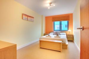 een slaapkamer met een bed en een raam bij Stephenson Sleepers Apartments by Week2Week in Gateshead