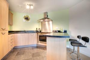 a kitchen with a stove and a counter top at Stephenson Sleepers Apartments by Week2Week in Gateshead