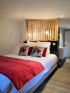 5 Chambres en Ville في كليرمون فيران: غرفة نوم بسرير كبير ومخدات حمراء وبيضاء