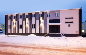 a building with lights on it in the snow at Marathon Noclegi in Skarżysko-Kamienna