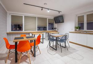 a kitchen with tables and chairs and a tv at Marathon Noclegi in Skarżysko-Kamienna +6 photos