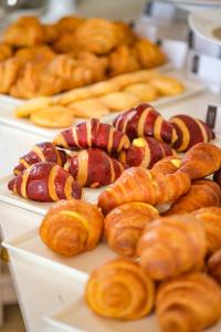 a bunch of different types of pastries on plates at Borgobianco Resort & Spa Polignano - MGallery Collection in Polignano a Mare