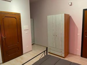 a bedroom with a bed and a wooden cabinet at Station's Room in Avellino