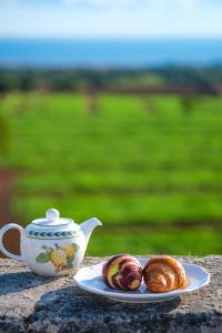 a plate of croissants and a teapot and a plate of pastry at Borgobianco Resort & Spa Polignano - MGallery Collection in Polignano a Mare