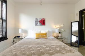 1 dormitorio con 1 cama grande y 2 mesas en Modern Loft with Rooftop Lounge in DTLA en Los Ángeles