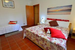 a bedroom with a bed with red pillows on it at Appartamento La Fenicia in Marciana Marina