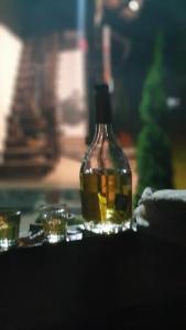 una botella de aceite con dos vasos pequeños en Casa Popa’s en Cîrţişoara