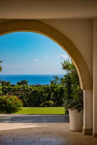 an archway in a building with a view of the ocean at Borgobianco Resort & Spa Polignano - MGallery Collection in Polignano a Mare