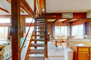 a spiral staircase in a cabin with a kitchen and dining room at Three Sheets to the Wind #70-1 in Avon