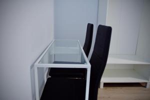 a glass desk with a black chair next to it at Pension Norte in Portugalete