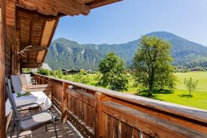 einen Balkon mit einem Tisch und Stühlen sowie Bergblick in der Unterkunft Frühstückspension Müllergut in Sankt Martin bei Lofer