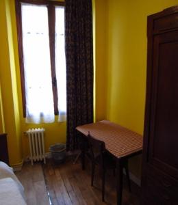 a room with a wooden table and a window at Hotel d'Orléans Paris Gare de l'Est in Paris