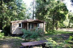 a wooden cabin in a field with a picnic table at LE GAHOUN - Chalet in Castets