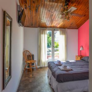 1 dormitorio con 1 cama grande y techo de madera en Hotel Los Ángeles en Mar del Plata