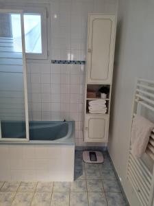 a bathroom with a tub and a cabinet and a scale at Maison indépendante in Lailly-en-Val