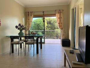 d'une salle à manger avec une table, des chaises et une fenêtre. dans l'établissement Delightful vacations apartment in Algarve, à Olhos de Água