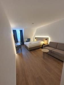 a hotel room with a bed and a couch at Hotel zur Traube in Möglingen