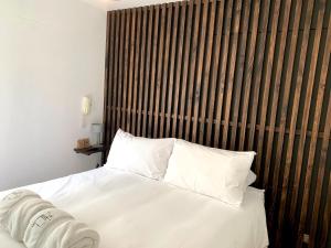 a bedroom with a bed with white sheets and pillows at Ayacucho apartments near Huaca Pucllana in Lima
