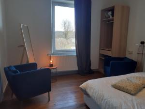 a bedroom with a bed and two chairs and a window at Vic Va la Vie in Éprave