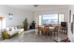 uma sala de estar com um sofá, uma mesa e cadeiras em 4 bedrooms apartement with furnished terrace and wifi at Recanati 8 km away from the beach em Recanati