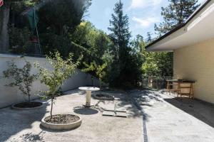 a patio with a table and trees and a fence at 4 bedrooms apartement with furnished terrace and wifi at Recanati 8 km away from the beach in Recanati