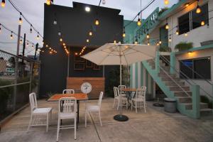 eine Terrasse mit einem Tisch, Stühlen und einem Sonnenschirm in der Unterkunft Mas Basico Hotel in Veracruz