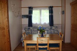 a dining room table with chairs and a window at LE GAHOUN - Chalet in Castets